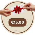 A €15 Brownie Girl gift card held between two hands, featuring a red ribbon and bow. The Brownie Girl logo appears in the top right corner of the card. The background shows soft beige and brown circular patterns, with “€15.00” displayed below the card and the note “T&Cs Apply” at the bottom