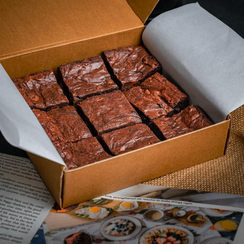 Box of nine Delight with Pan Di Stelle Spread brownies arranged in a neat grid, featuring glossy cracked tops and premium bakery-style packaging.