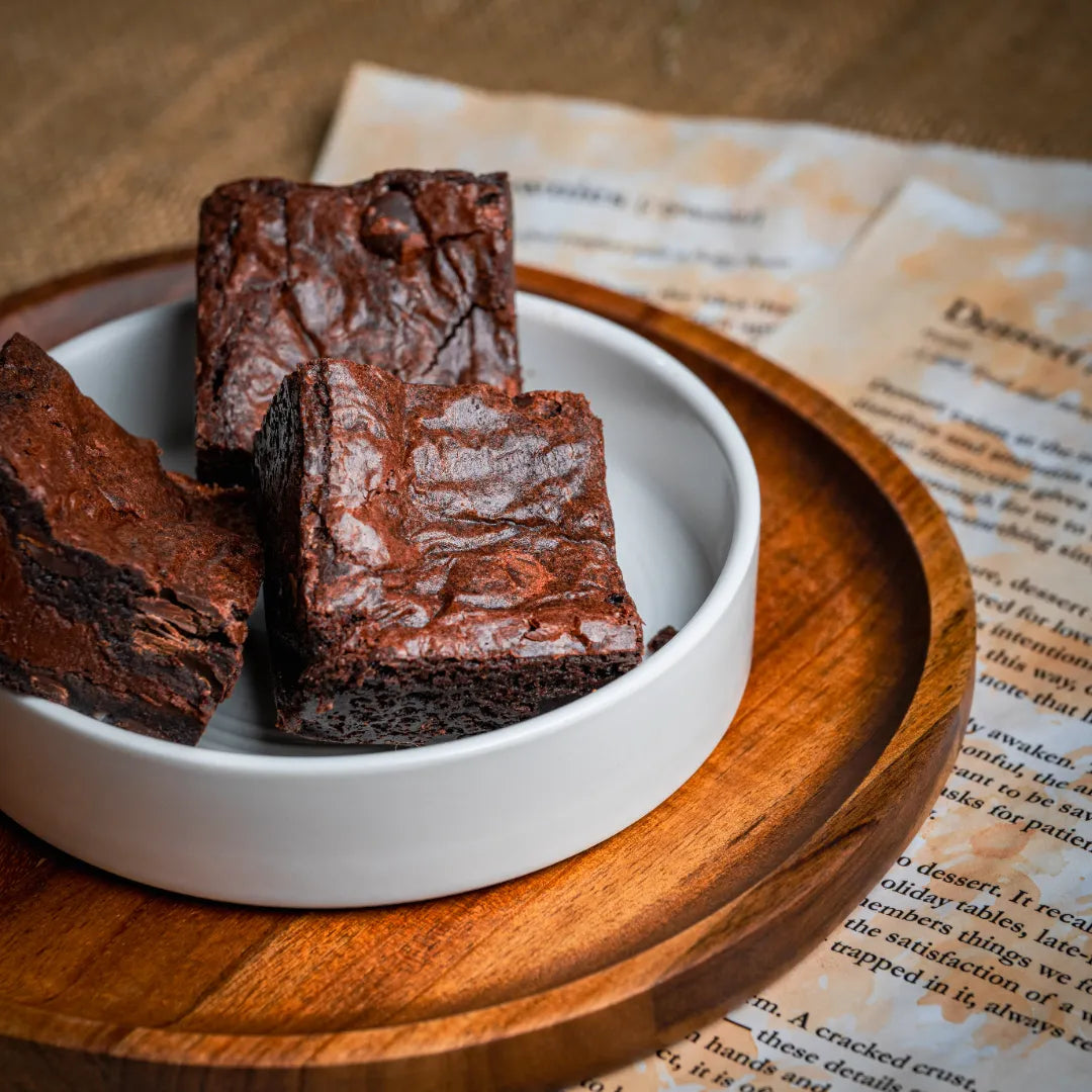 Three Delight with Pan Di Stelle Spread brownies served in a white bowl on a wooden tray, emphasizing their glossy tops and rich, fudgy texture.