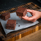 Three Wine & Dine brownies on a cooling rack, featuring a moist, cake‑like dark‑chocolate texture enhanced with espresso coffee and Merlot wine.